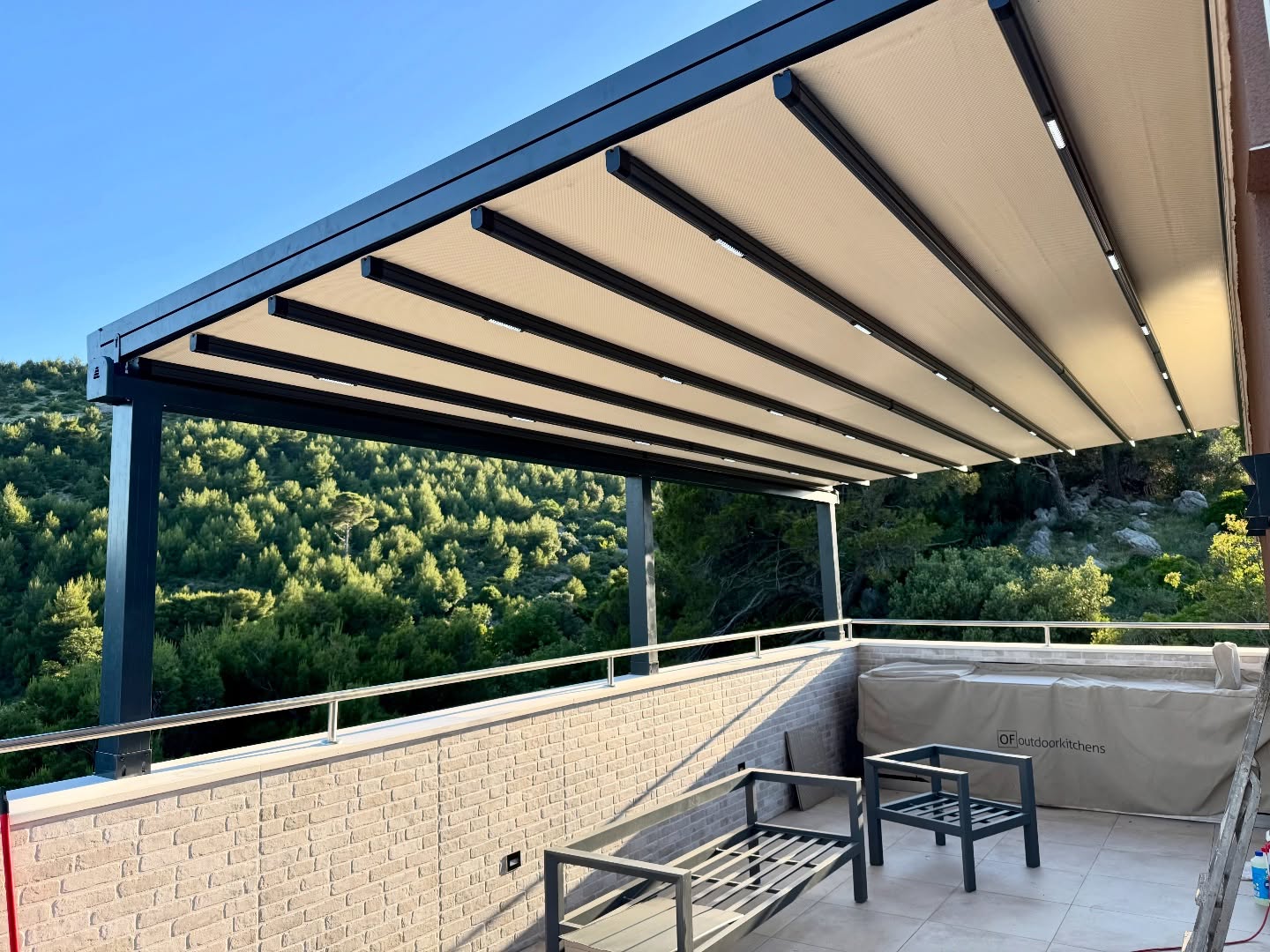 Pergola awning on elevated terrace overlooking forest — evening light, anthracite system exported from Turkey