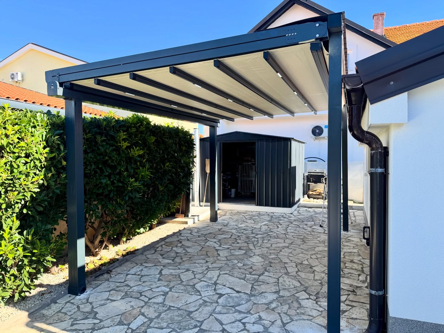 Pergola awning side view on stone garden terrace — drainage post detail visible, Turkey export system