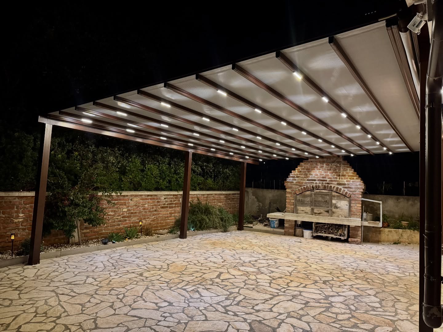 Pergola awning with integrated LED lighting at night — brown aluminum frame, Turkey export manufacturer