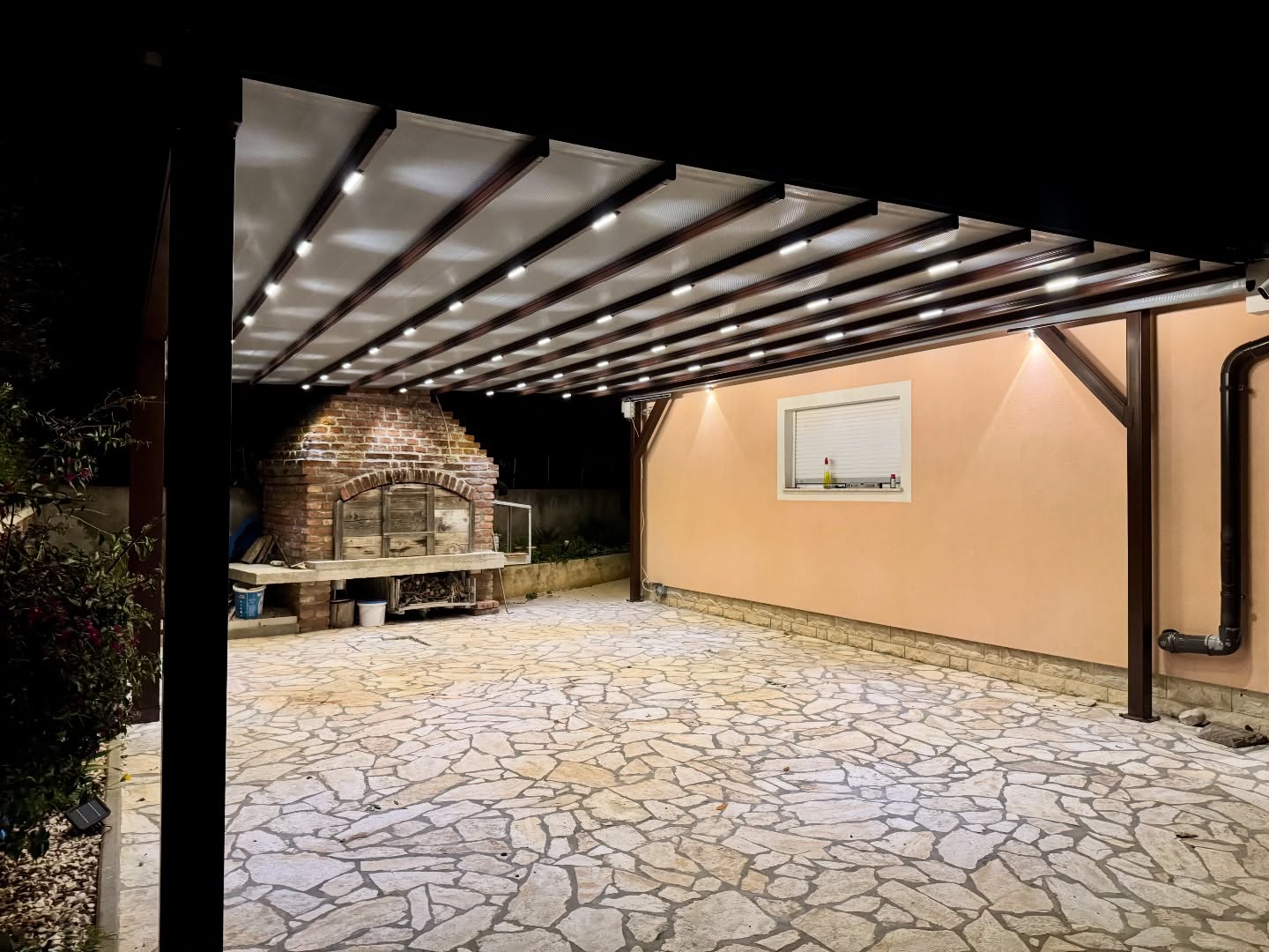 Side angle night photo of pergola awning with LED lighting — residential outdoor space, Turkey manufacturer