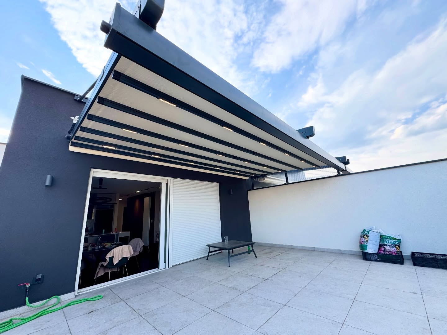 Wide angle view of pergola awning covering rooftop terrace — motorized aluminum system manufactured in Turkey