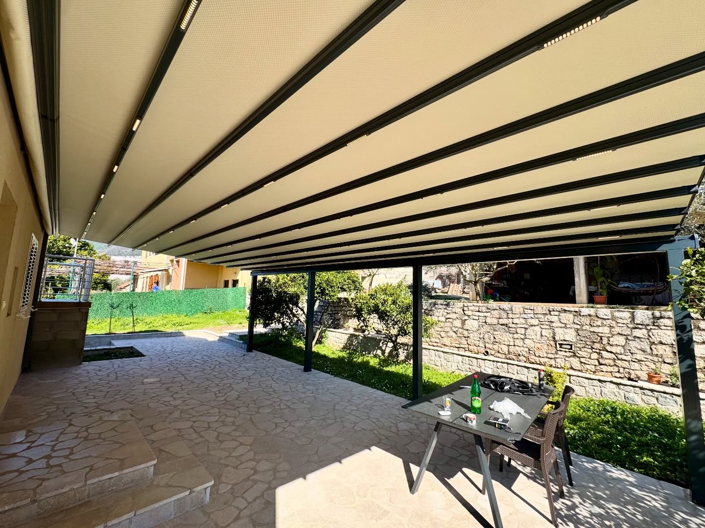 Interior view of pergola awning over garden dining area — fabric louver system with LED, Turkey manufacturer