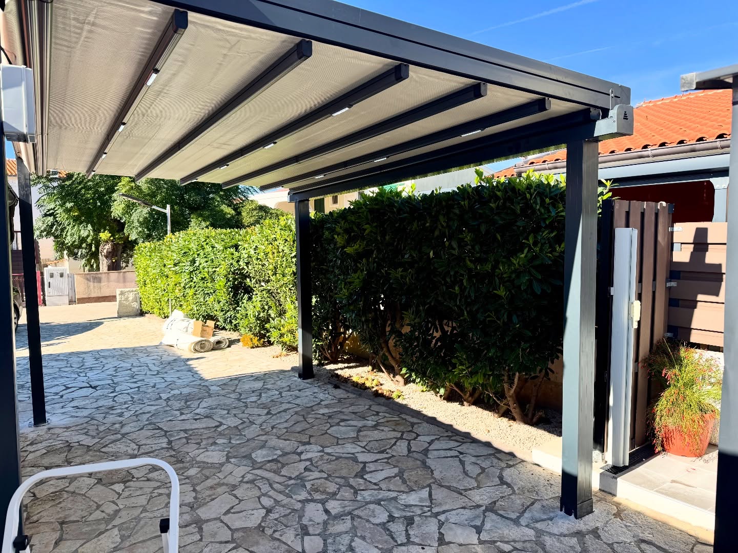 Pergola awning installation on stone-paved garden — anthracite aluminum frame, Turkey manufacturer
